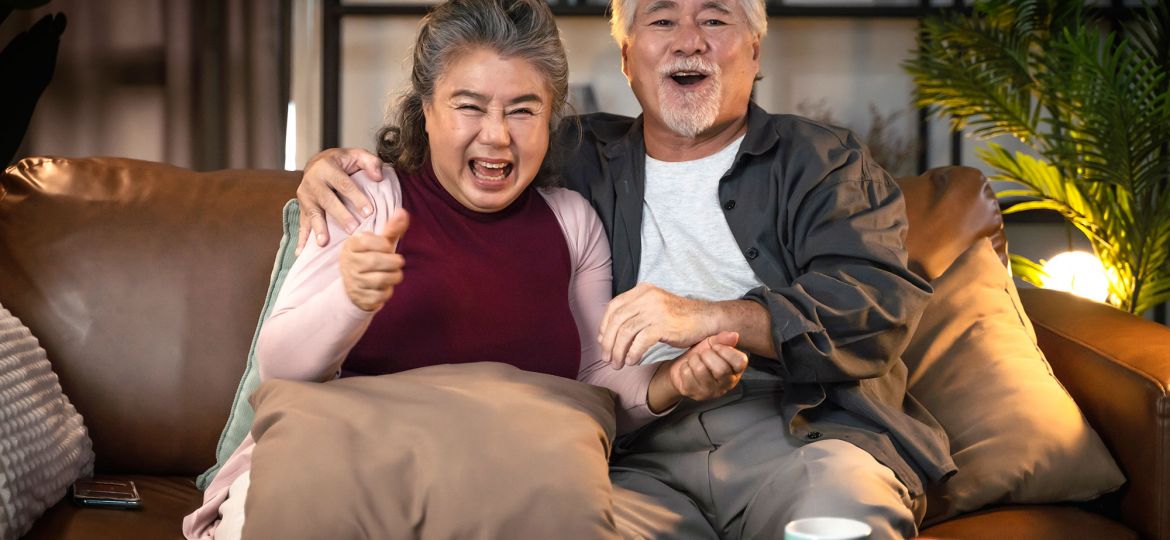 old-retired-age-asian-couple-watching-tv-homeold-mature-asian-couple-cheering-sport-games-competition-together-with-laugh-smile-victory-sofa-couch-living-room-home-isolation-activity
